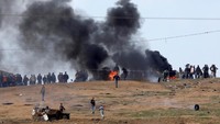 Dalam aksinya, sejumlah demonstran Palestina melakukan aksi pembakaran di wilayah Gaza, dekat perbatasan Israel. Asap pekat akibat aksi pembakaran ini terlihat mebubung ke angkasa. Foto: REUTERS/Amir Cohen