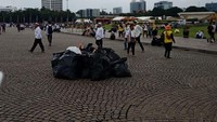 Usai acara, para peserta aksi memunguti sampah-sampah yang berserakan ke dalam kantong sampah/Foto: Kanavino Ahmad Rizqo