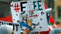 Mereka membawa sejumlah poster dan spanduk. Salah satunya berisi karikatur Donald Trump (Foto: Dok. REUTERS/Ralph Orlowski)