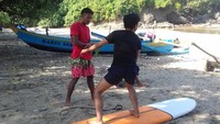 Foto: Ada banyak pemuda lokal yang sudah mahir menari diatas surf board. Mereka tentu siap jadi guide bagi wisatawan yang ingin belajar main surfing. (dok. istimewa)
