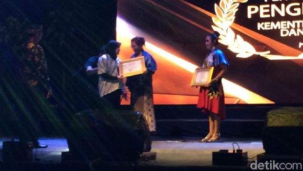 Menteri Susi menyerahkan piagam ke Pimpian Redaksi detikcom. 