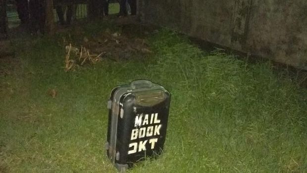 Koper tersebut berwarna hitam dan ada tulisan di bagian luarnya.