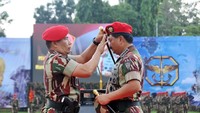 Danjen Kopassus Mayjen TNI Madsuni memakaikan baret merah Kopassus ke kepala Marsekal Hadi yang tampak memejamkan mata. 