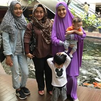 Wanita 23 tahun ini berpakaian syari ketika pergi ke mal menggunakan setelan gamis dan khimar warna ungu. Nadya Almira tak menambahkan bros atau hiasan di kerudung agar tidak melukai sang buah hati ketika akan menggendongnya. Foto: Dok. Instagram @nadya_almira