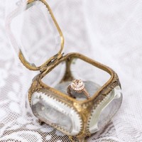 Untuk dia yang memiliki pribadi feminin dan unik, kotak cincin bernuansa vintage dan rustic bisa jadi opsi. Seperti kotak cincin kaca dengan bingkai emas lusuh ini. Foto: Pinterest