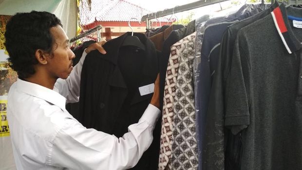 Calon pembeli sedangmemilih baju wabup yang hendak dibeli