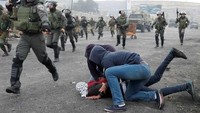Mustaribeen beraksi menahan pengunjuk rasa Palestina yang memprotes keputusan Presiden Amerika Serikat Donald Trump  mengakui Yerusalem sebagai ibu kota Israel. Demonstrasi terjadi di dekat permukiman Yahudi Beit El, Kota Ramallah, Tepi Barat, Rabu (13/12/2017).(REUTERS/GORAN TOMASEVIC)