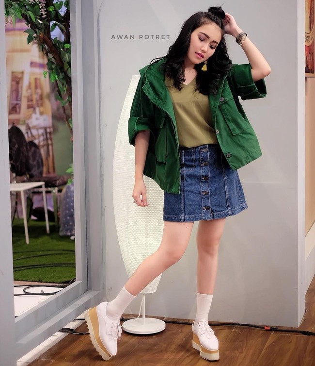 Memadukan rok jeans mini dengan jaket dan kaus kaki, Ayu Ting Ting bergaya maksimal ala gadis Korea. Ditambah lagi rambutnya ditata cepol tinggi yang memang gaya khas wanita Negeri Gingseng. Foto: Dok. Awan Potret