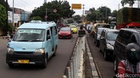 Mobil pribadi hingga angkot melawan arus untuk menghindari macet di lampu merah di perempatan kawasan industri Pulogadung.