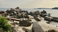 Nampak selalu ceria dalam bertualang, itulah Farah Quinn. Inilah penampakan pantai khas Pulau Bintan dengan bebatuan besarnya (farahquinnofficial/Instagram)
