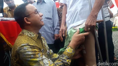 Foto: Saat Anies Pasangkan Kaki Palsu ke Lansia di Monas