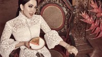 Tengah sibuk berbisnis kue, Syahrini kerap memposting kue dagangannya. Kali ini ia duduk sambil memegang sepiring kue bakpia. Cantik berkebaya modern warna putih. Foto: Instagram @princessyahrini