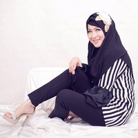 Okie Agustina tampil monokrom dengan perpaduan gaya hitam-putih memakai setelan celana dan striped blouse. Gaya hijabnya dibuat simpel dan polos. Ia menambahkan bros di atas kerudung yang menambah kesan elektrik.  Foto: Dok. Instagram @mrs.gdc13