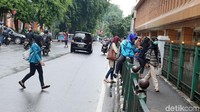 Para calon penumpang kereta api melompati pagar pedestrian di Stasiun Cikini, Jakarta. KAI tetap mempertahankan pagar Stasiun Cikini meski sering dilompati. Pagar itu dinilai penting demi ketertiban dan keselamatan penumpang. (Ari Saputra/detikcom)