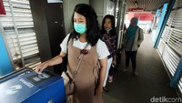 Calon penumpang cukup menempelkan kartu OK Otrip ke mesin tiket untuk masuk ke halte TransJakarta.