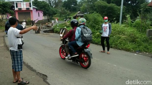 Warga memberi informasi pada pengguna jalan.