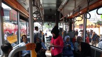 Foto: Seorang petugas membagikan tiket bertuliskan tiket layanan gratis kepada penumpang. Fotografer: Haris Fadhil/detikcom