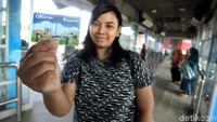 Calon penumpang TransJakarta menunjukkan kartu OK Otrip di Halte Penas Halim, Jakarta, Jumat (22/12/2017).