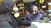 Mereka ingin menegur pelanggaran-pelanggaran soal kawasan tanpa rokok, dengan cara yang berbeda. Dengan menggunakan masker respirator, mereka mendatangi tenant-tenant yang pengunjungnya banyak merokok di dalam ruangan. (Foto: GEBRAK)