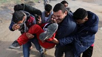 Demonstran Palestina berpakaian Santa Claus dievakuasi oleh rekannya karena terluka setelah bentrok dengan pasukan Israel dalam aksi protes di kawasan selatan Kota Gaza. REUTERS/Mohammed Salem.