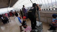 Warga melihat lanskap Jakarta dari puncak Monas.