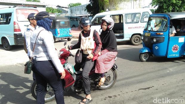 Petugas yang berjaga memberi petunjuk kepada pemotor