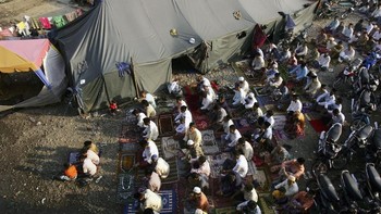 Melaksanakan Idul Adha pasca terjadinya tsunami Aceh di tanah lapang kamp pengungsian pada 21 Januari 2005. (Foto: Spencer Platt/Getty Images). 