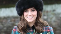 Ibu dua anak itu tampil cantik dengan coat bermotif kotak-kotak dan topi hitam. (Foto: Chris Jackson/Getty Images)