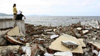 Korban selamat memandangi pantai Ulhe Lheue pasca terjadinya tsunami Aceh. Dimas Ardian/Getty Images