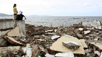Korban selamat memandangi pantai Ulhe Lheue pasca terjadinya tsunami Aceh. (Foto: Dimas Ardian/Getty Images)