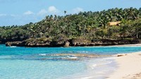 Pantai eksotis berpasir putih pun menyambut kedatangannya. Perbukitan hijau menjadi latarnya. Lebih dekat ke pantai, perairannya biru jernih yang mana ikan laut dan karang-karang terlihat jelas di bawah kapalnya (Tanveer Badal/BBC Travel)