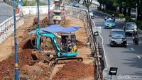 Ekskavator melakukan pengerukan untuk pembangunan tiang pancang LRT.