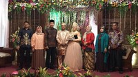Presiden Jokowi dan Ibu Negara Iriana menyusuri gang sempit di Bogor untuk menghadiri resepsi pernikahan anak perawat rusa Istana Bogor, Rabu (27/12/2017). Jokowi mengenakan batik lengan panjang dan Iriana berkebaya merah dan kerudung. Paspampres hanya bermodal peta di undangan saja untuk mencari lokasinya. Bahkan Jokowi dan rombongan butuh senter sebagai penerang jalan. Foto: Dok. Istimewa
