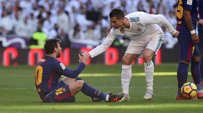 Soccer Football - La Liga Santander - Real Madrid vs FC Barcelona - Santiago Bernabeu, Madrid, Spain - December 23, 2017   Real Madrid’s Cristiano Ronaldo helps Barcelona’s Lionel Messi get back to his feet   REUTERS/Sergio Perez