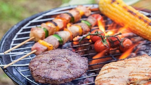 Tasty Kebabs Shishkabobs on Grill with wood skewers, and a medley of food being grilled to perfection in a shallow depth of focus look.  Chicken, pepper, onions, glaze and squash.