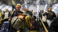 Beberapa orang traveler tampak tergesa-gesa menuruni tangga. Mereka ingin mengejar kereta agar cepat sampai ke tempat tujuan (Stephanie Keith/Reuters)