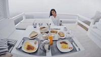 Sedang berlibur ke Yunani, kekasih Indra Priawan ini mengenakan jubah mandi berwarna putih bergaya cantik dan seksi dengan deretan hidangan sarapan. Ada scrambled egg, sosis, roti hingga jus buah. Foto: Instagram Nikita Willy
