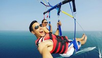 Hobinya bertualang membuatnya tak ragu melakukan parasailing bersama sang istri. (Foto: instagram/darius_sinathrya)