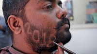 Seorang pria di India punya cara tersendiri untuk menyambut tahun baru 2018. Ya, dia sengaja mengukir angka 2018 di sekitar jenggotnya. REUTERS/Amit Dave.