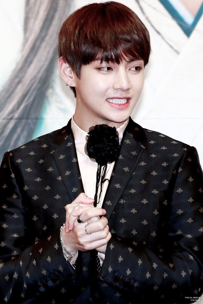 Setelan jas hitam dan korsase pada bagian kerah membuat penampilan V terlihat classy dan elegan. Foto: istimewa