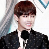 Setelan jas hitam dan korsase pada bagian kerah membuat penampilan V terlihat classy dan elegan. Foto: istimewa