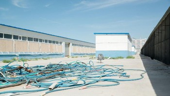 Kabel-kabel berserakan di luar gedung pertambangan Bitcoin. Foto: Quartz