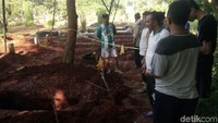 Beberapa warga dan penjaga makam tengah berada di lokasi. 