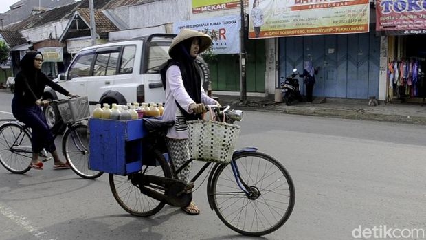Opi melayani pembeli jamu