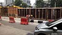 Foto: Sejumlah pekerja terlihat sedang mengecat bagian bawah flyover dengan warna hitam dan putih. Ada pula yang mengerjakan bagian dinding jalan yang belum selesai dicor. (Haris Fadhil-detikcom)