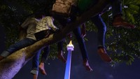 Potret warga yang duduk-duduk di pohon demi menyaksikan acara hiburan (Foto: ANTARA FOTO/Wahyu Putro A)