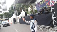 Petugas berjaga di depan panggung besar dan sejumlah ondel-ondel yang disiapkan menyambut perayaan tahun baru 2018 di kawasan Bundaran Hotel Indonesia, Jakarta, Minggu (31/12/2017).