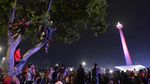Foto: Memanjat Pohon Demi Rayakan Tahun Baru di Monas