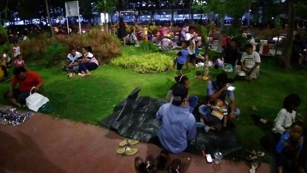 Abaikan larangan, banyak warga yang duduk di atas rumput