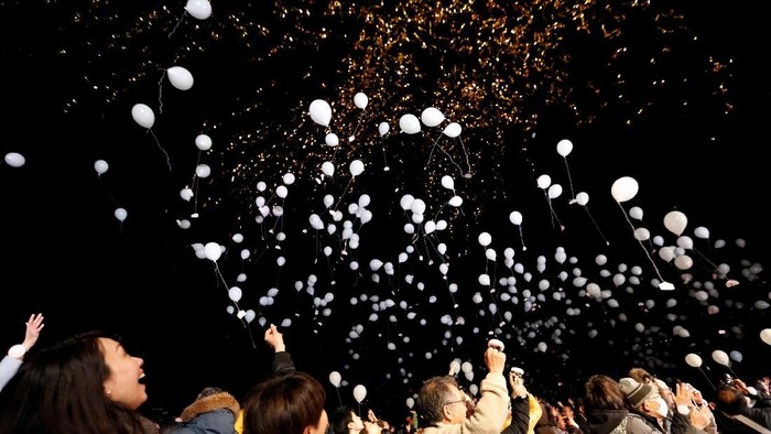 People release balloons as they take part in a New Year countdown event in celebrations to ring in 2018 in Tokyo, Japan January 1, 2018. REUTERS/Toru Hanai
